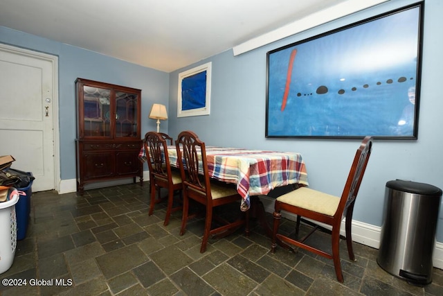 dining area with stone finish flooring and baseboards