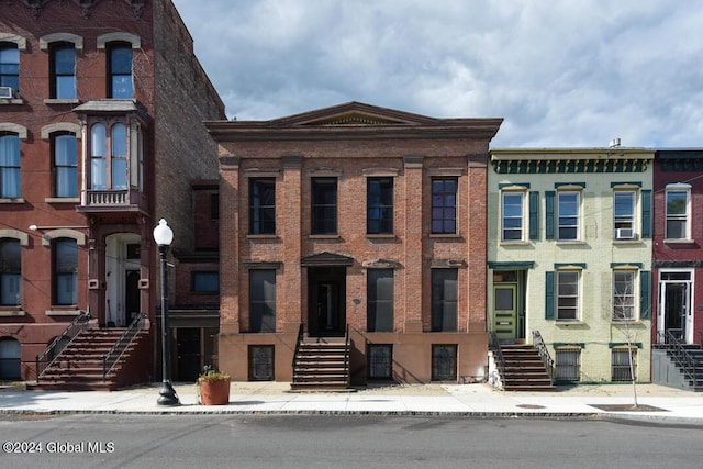 view of front of home with brick siding and stairway
