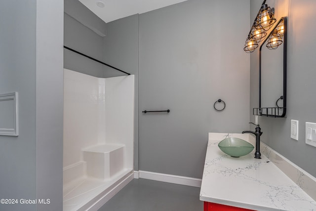 bathroom with concrete flooring, vanity, and a shower