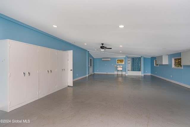 unfurnished living room with vaulted ceiling, concrete floors, a wall unit AC, and ceiling fan