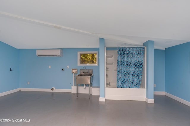 basement with a wall unit AC and sink