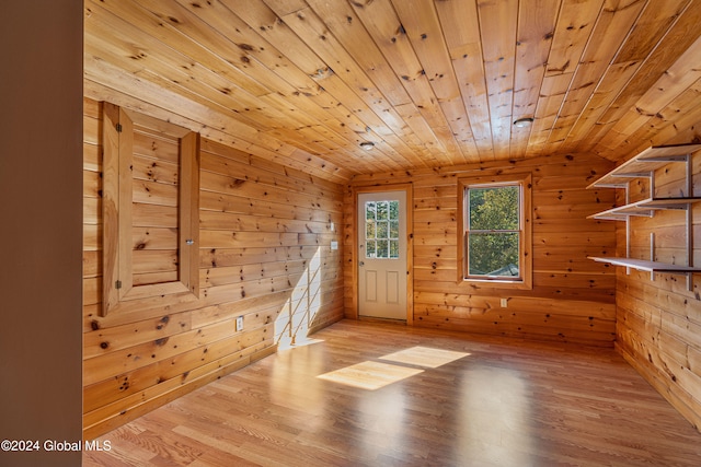 interior space with light wood-type flooring, wood walls, and wooden ceiling