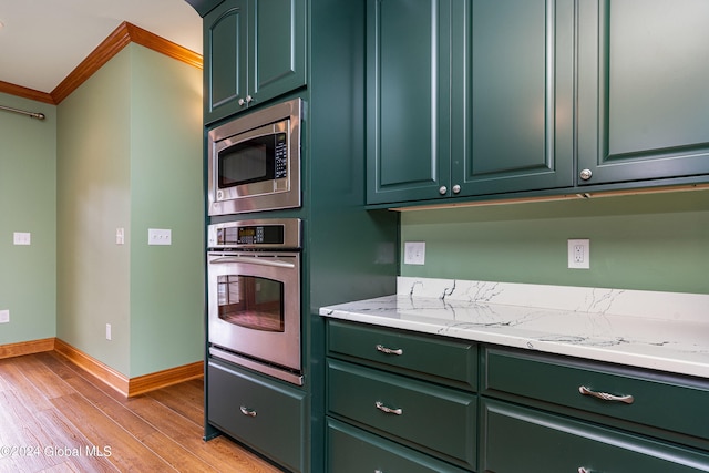 kitchen with stainless steel appliances, light hardwood / wood-style floors, crown molding, and light stone counters