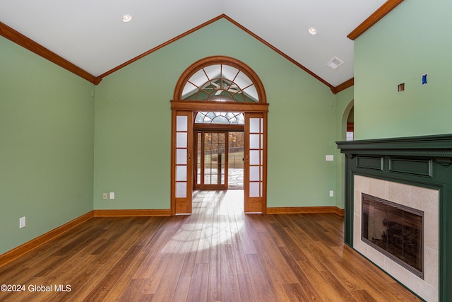 unfurnished living room with lofted ceiling, ornamental molding, hardwood / wood-style flooring, and a fireplace