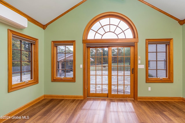 doorway featuring hardwood / wood-style flooring, crown molding, a wealth of natural light, and a wall mounted air conditioner