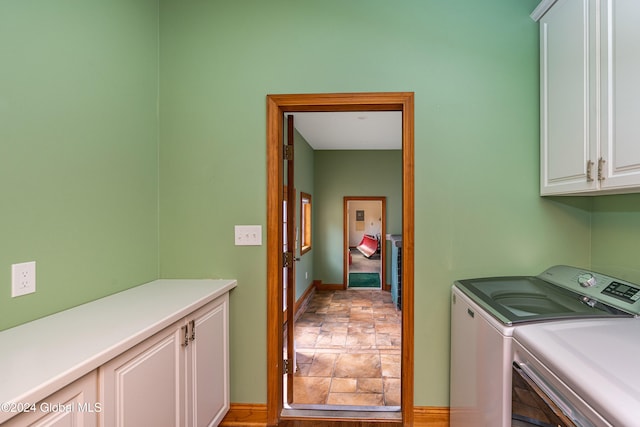 washroom with cabinets and washer and clothes dryer