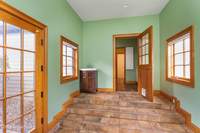 stairway featuring a healthy amount of sunlight and wood-type flooring