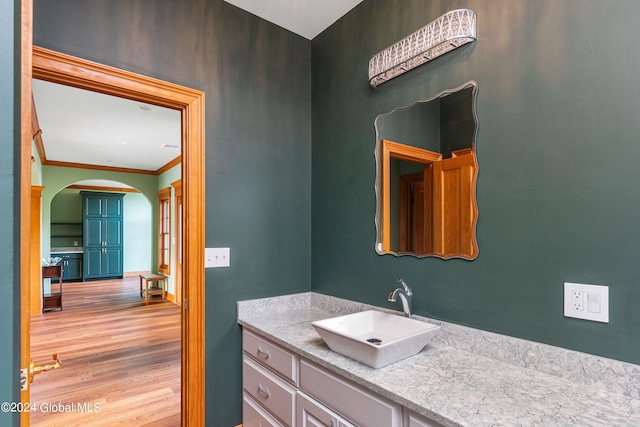 bathroom featuring vanity, hardwood / wood-style flooring, and crown molding