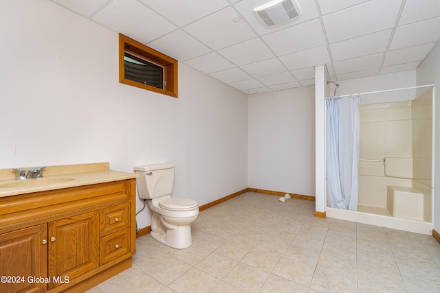 bathroom featuring walk in shower, vanity, a paneled ceiling, tile patterned floors, and toilet