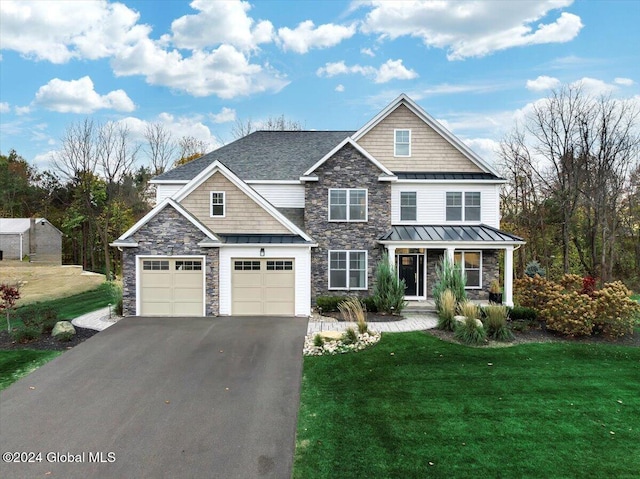 view of front of property featuring driveway, a front lawn, a standing seam roof, a porch, and metal roof