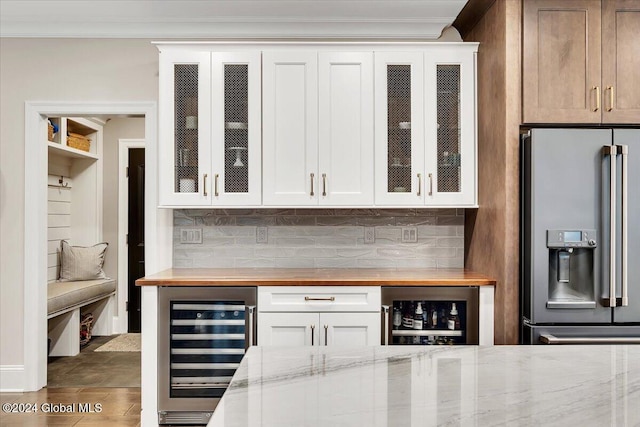 bar with wine cooler, stainless steel fridge with ice dispenser, tasteful backsplash, and ornamental molding