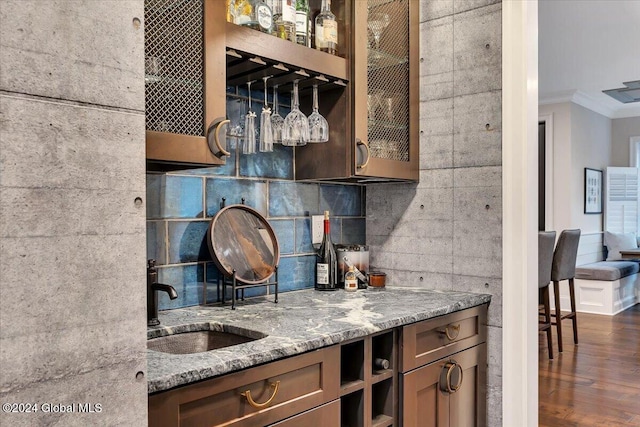 kitchen with ornamental molding, tasteful backsplash, stone counters, and a sink