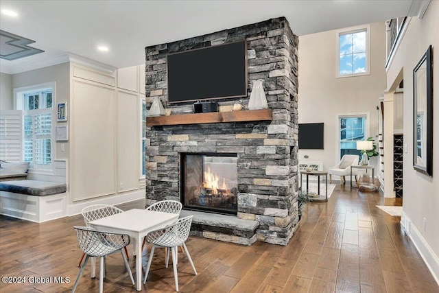 living area featuring wood finished floors, a fireplace, and baseboards