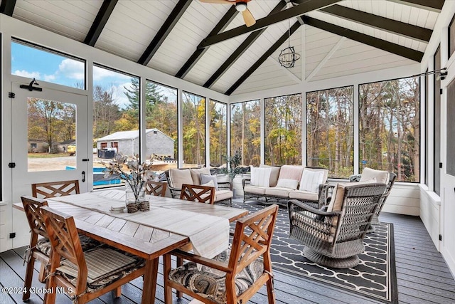 sunroom / solarium featuring plenty of natural light, a ceiling fan, and vaulted ceiling with beams