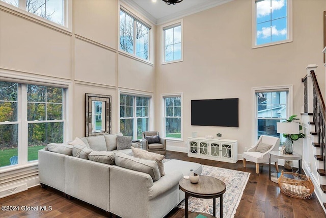 living room with stairway, visible vents, plenty of natural light, ornamental molding, and dark wood-type flooring