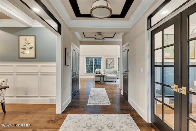 hallway with dark wood-style flooring, french doors, wainscoting, crown molding, and a decorative wall