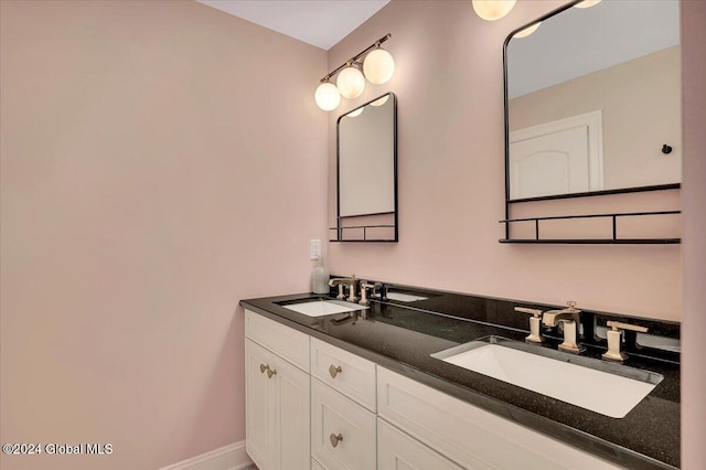 full bathroom with a sink, baseboards, and double vanity