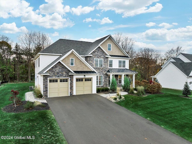 view of front of home featuring a front lawn, aphalt driveway, metal roof, an attached garage, and a standing seam roof