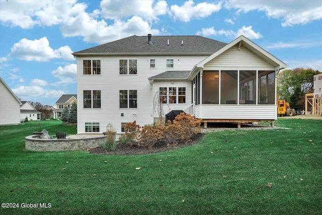 back of house featuring a yard, a fire pit, a patio area, and a sunroom