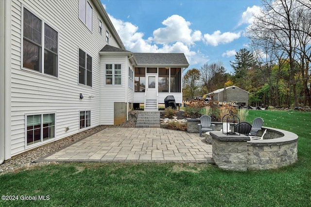 view of patio with a sunroom and an outdoor fire pit