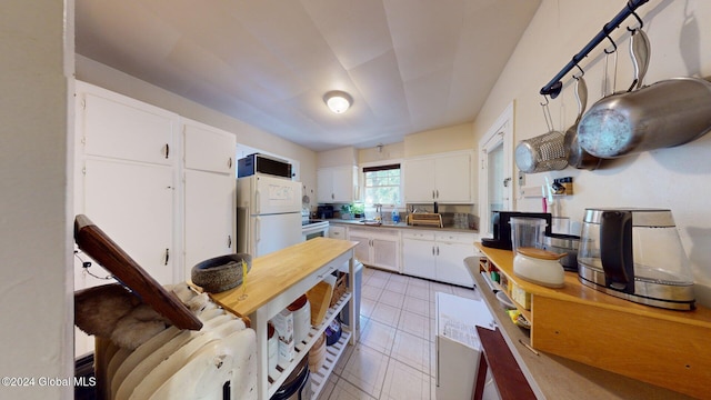 kitchen featuring white cabinets, sink, and white appliances