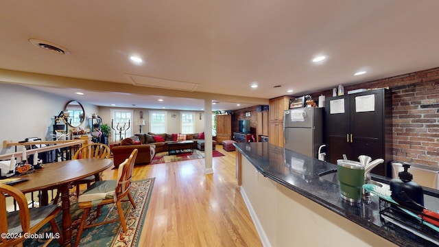 interior space featuring brick wall and light hardwood / wood-style floors