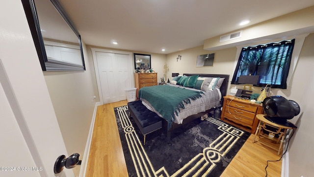 bedroom with wood-type flooring and a closet