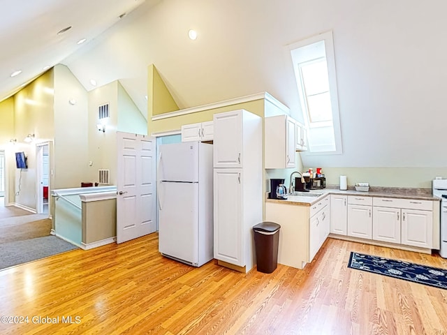 kitchen with white cabinets, light wood-type flooring, sink, and white appliances