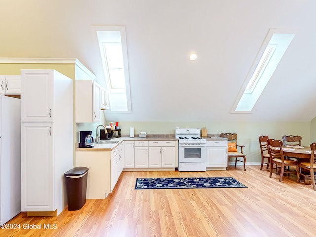 kitchen with light wood-type flooring, a wealth of natural light, white appliances, and sink