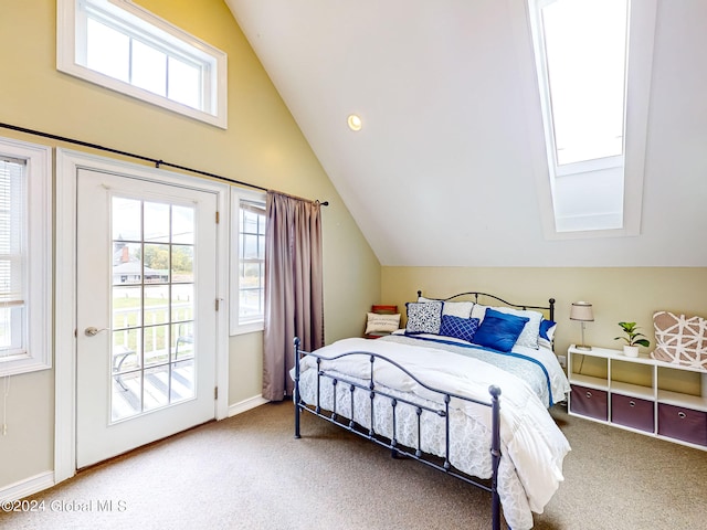 bedroom featuring access to exterior, multiple windows, carpet, and vaulted ceiling with skylight