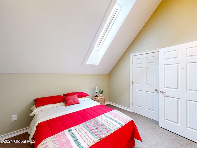 bedroom with lofted ceiling with skylight, a closet, and carpet flooring