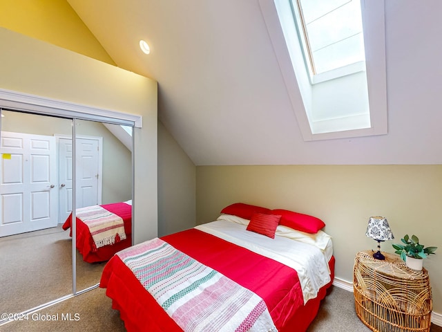 bedroom with lofted ceiling with skylight, carpet floors, and a closet