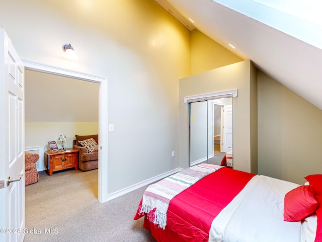 carpeted bedroom with lofted ceiling and a closet