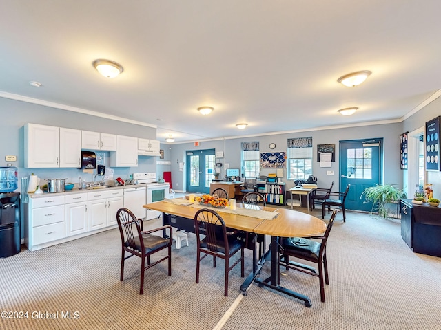 dining area featuring crown molding, light colored carpet, and sink