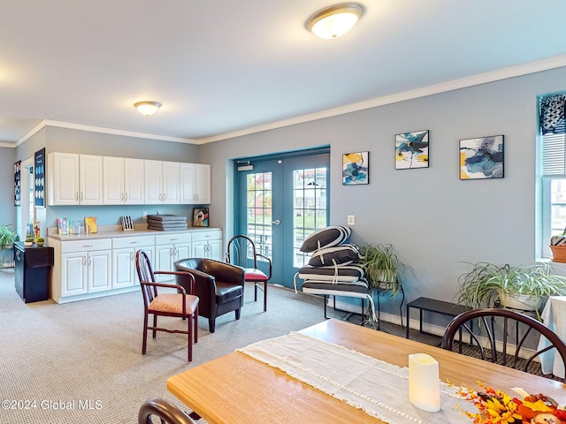 dining area with ornamental molding, light carpet, and french doors