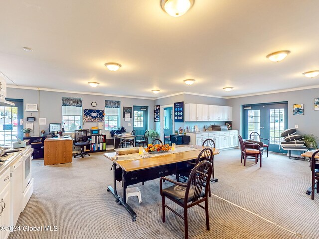 dining area featuring ornamental molding and light colored carpet