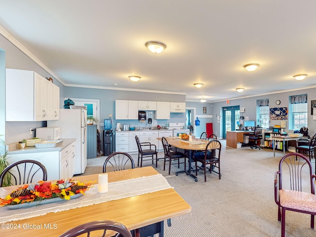 carpeted dining room featuring crown molding