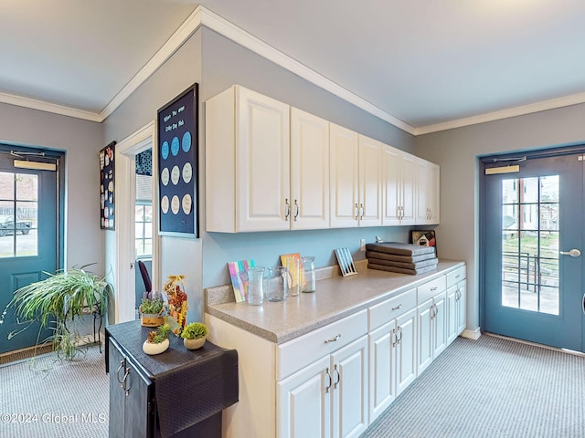 kitchen with plenty of natural light, crown molding, and white cabinetry