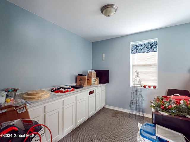 kitchen with carpet floors and white cabinets