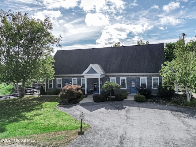 cape cod house with a front lawn