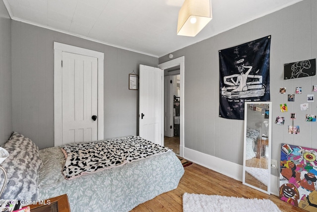 bedroom featuring wood-type flooring and crown molding