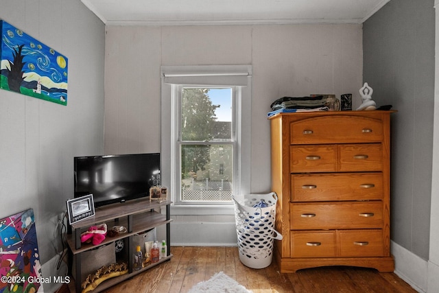 sitting room with crown molding and light hardwood / wood-style floors