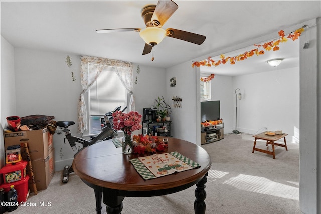 carpeted dining room with ceiling fan