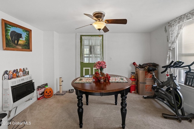 dining room featuring ceiling fan, heating unit, and carpet