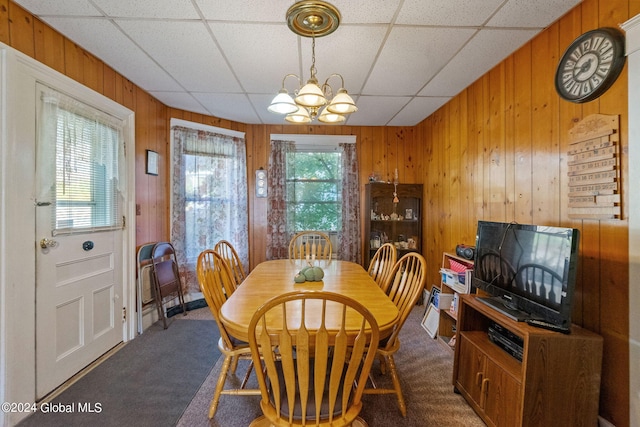 dining room with a drop ceiling, plenty of natural light, and dark carpet