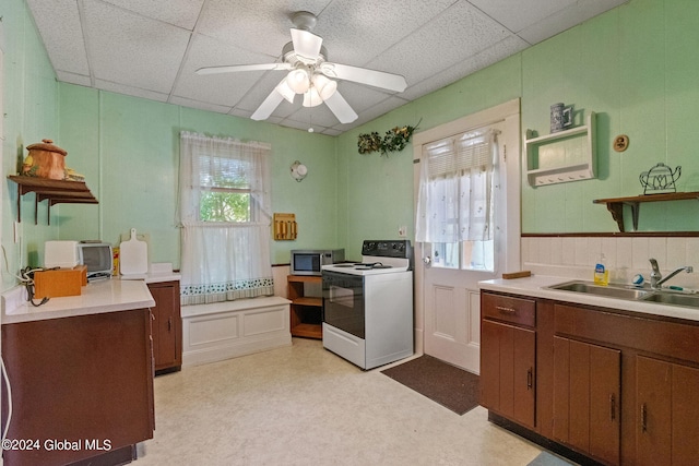 kitchen featuring sink, a paneled ceiling, white electric stove, and a wealth of natural light