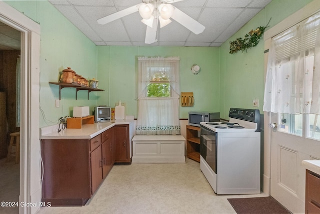 kitchen featuring ceiling fan, white electric range oven, and a paneled ceiling