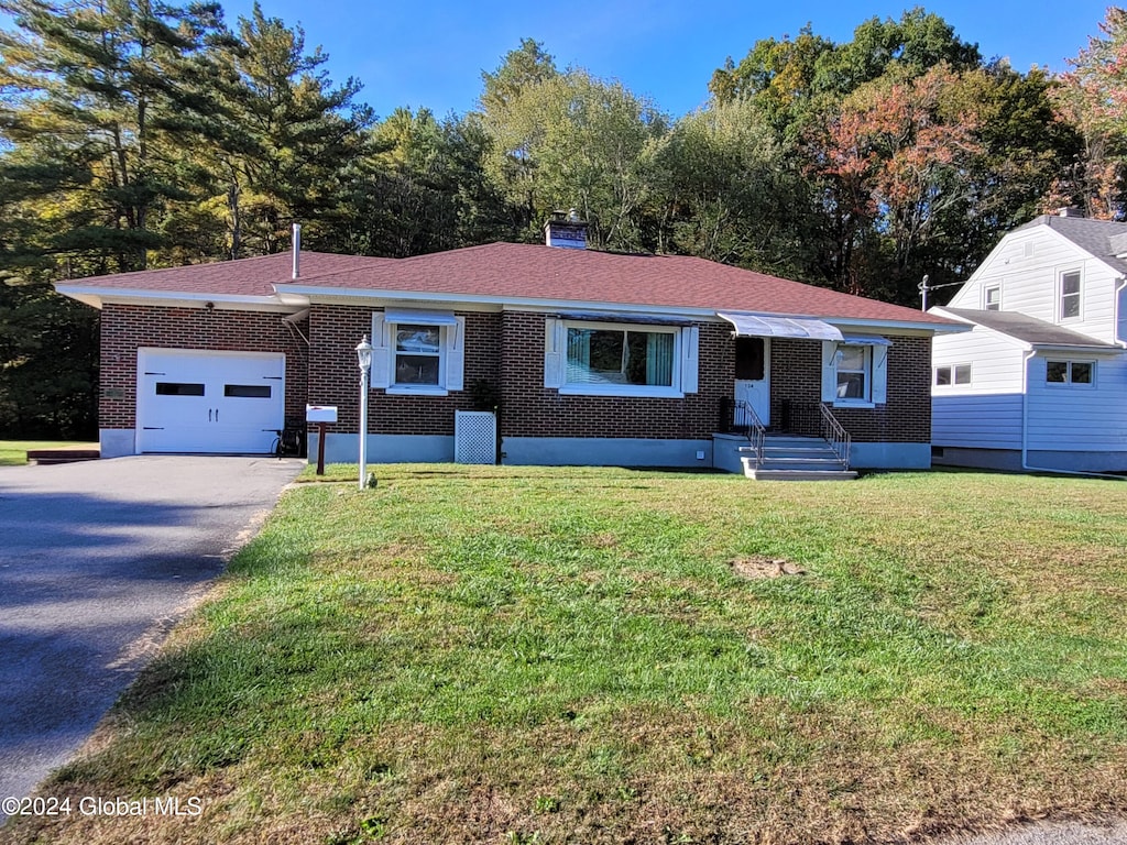 single story home with a garage and a front lawn