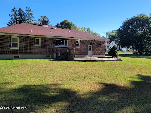 back of house with a patio, a yard, and central AC