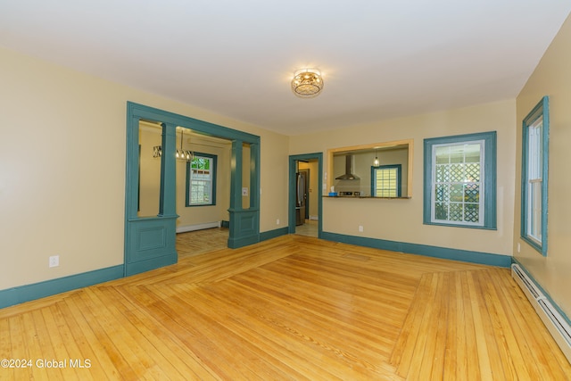 unfurnished room featuring light hardwood / wood-style flooring and baseboard heating